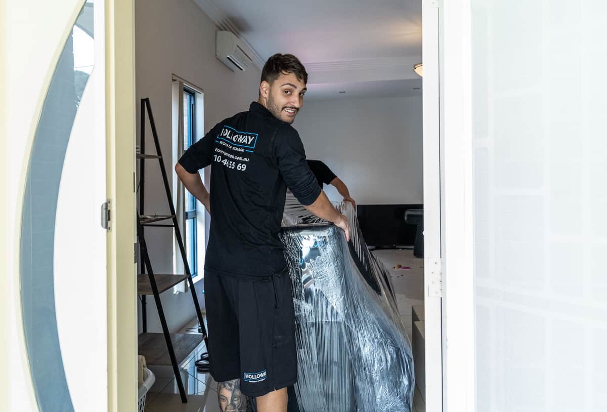 Removalists moving furniture in a house