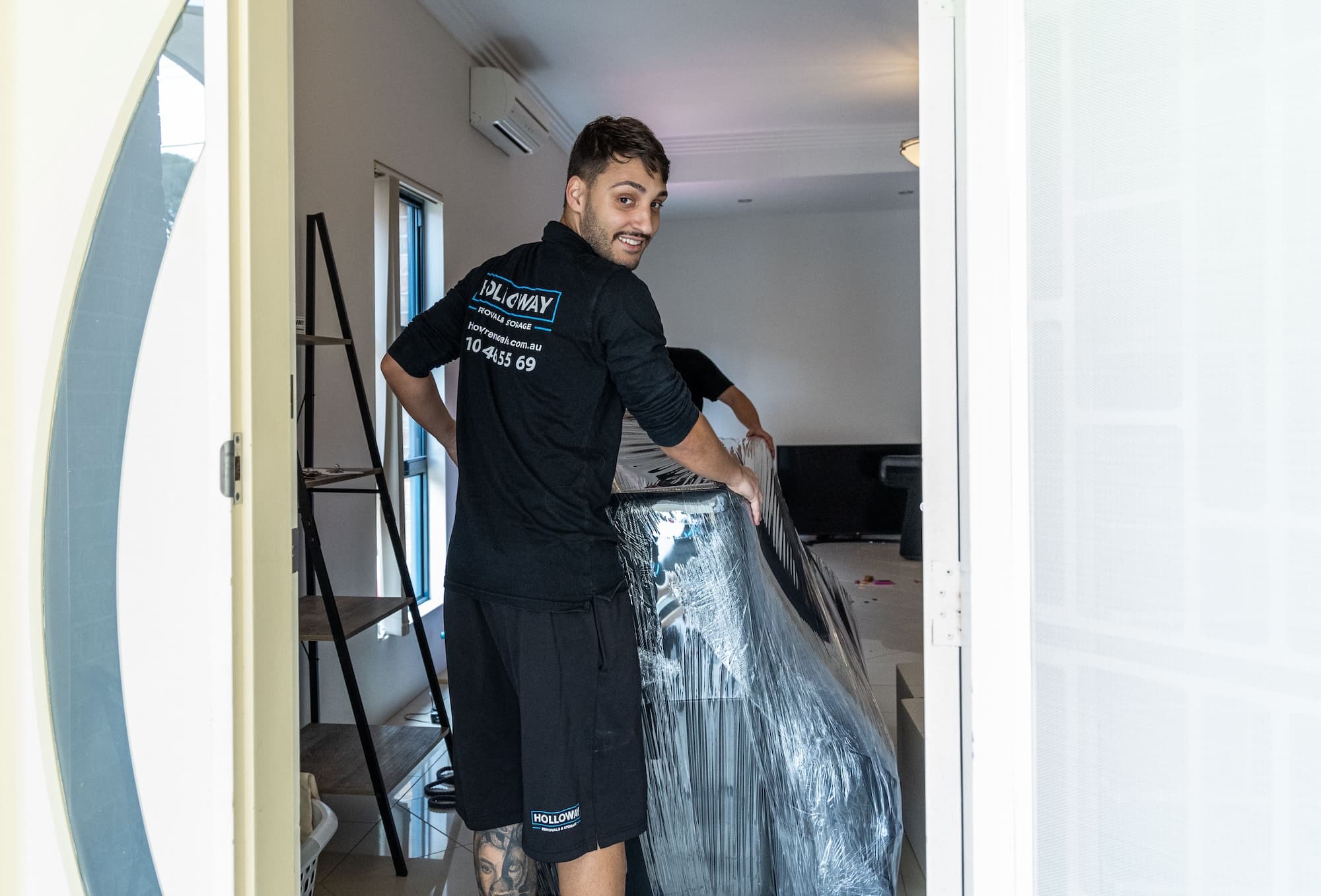Removalists moving furniture in a house