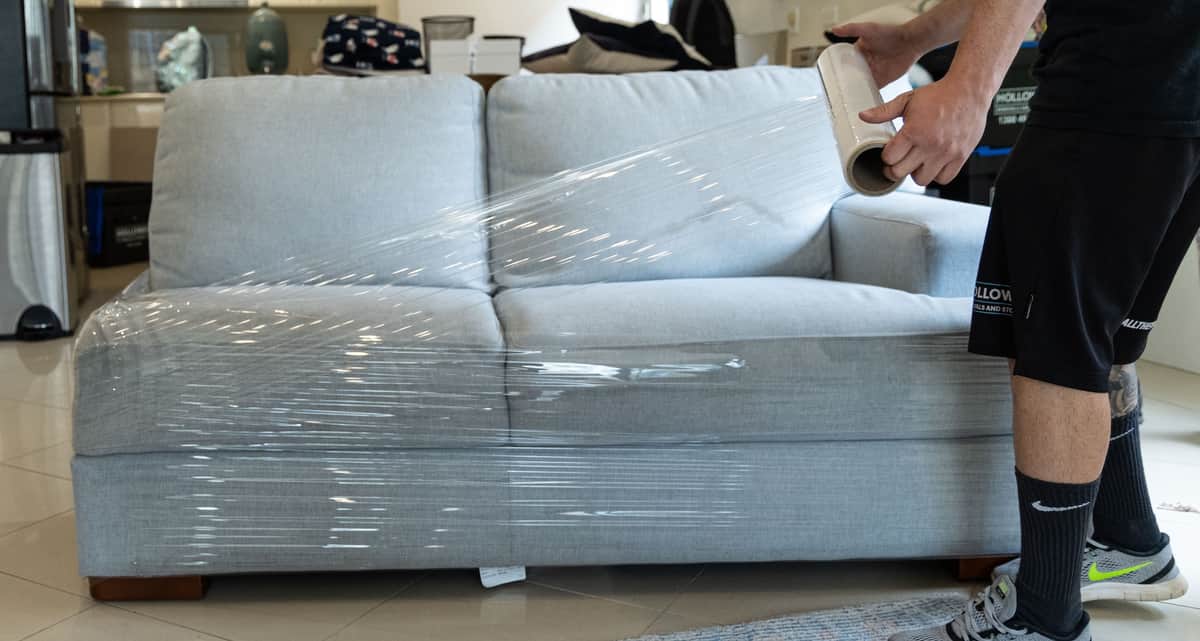 Removalists wrapping furniture