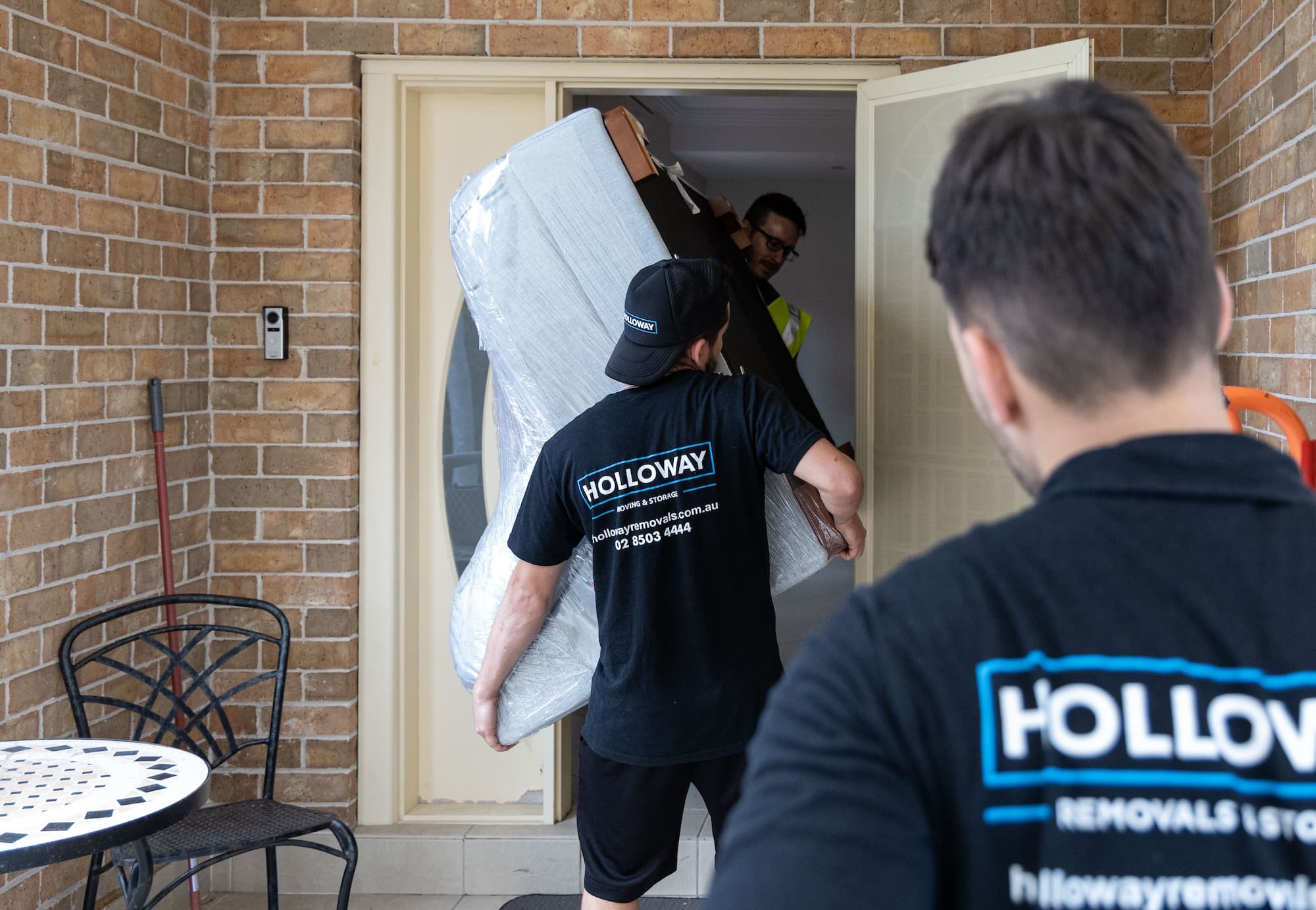 Removalists moving furniture in a house
