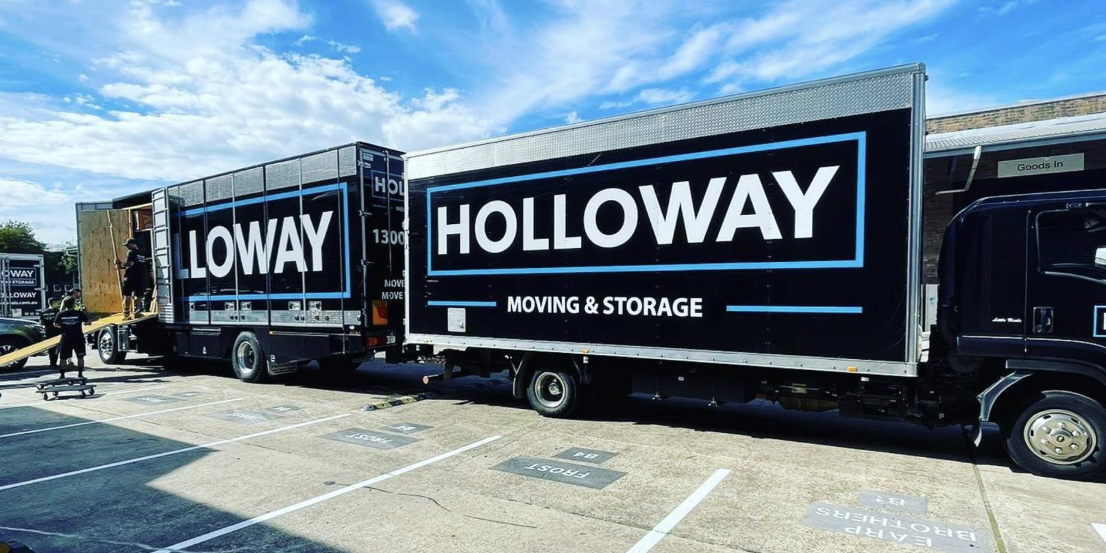 Two Holloway trucks parked at a warehouse