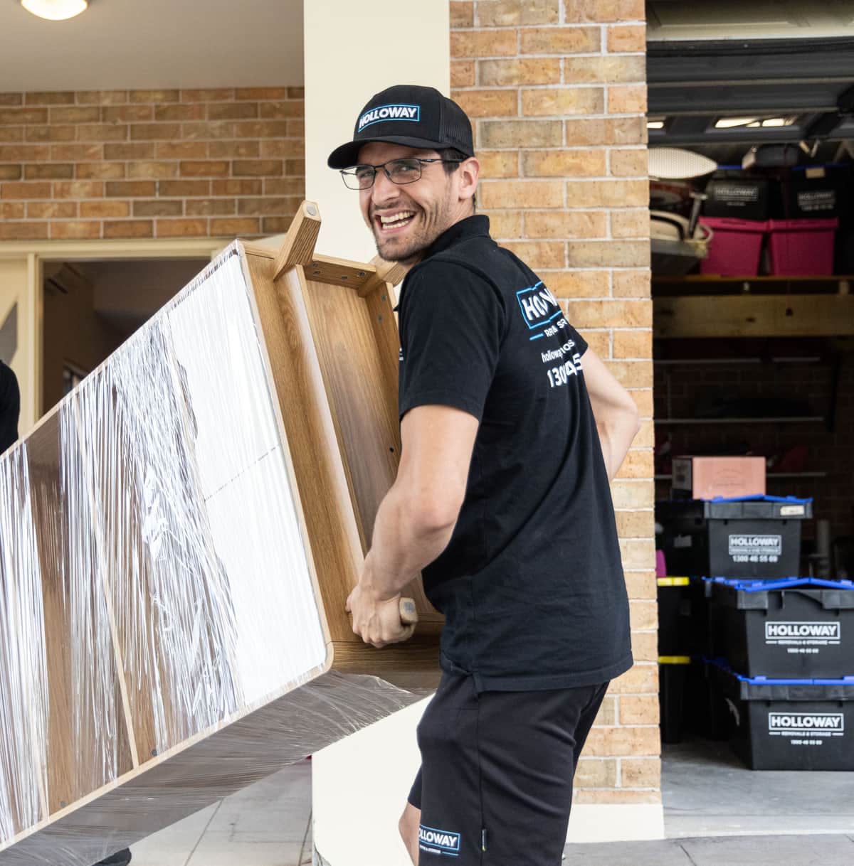 Holloway team moving a cabinet wrapped and protected in shrink wrap