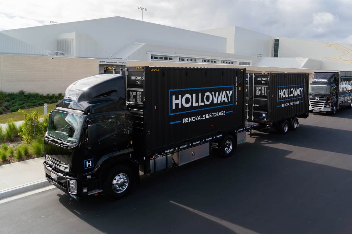 Holloway team posing in front of a truck