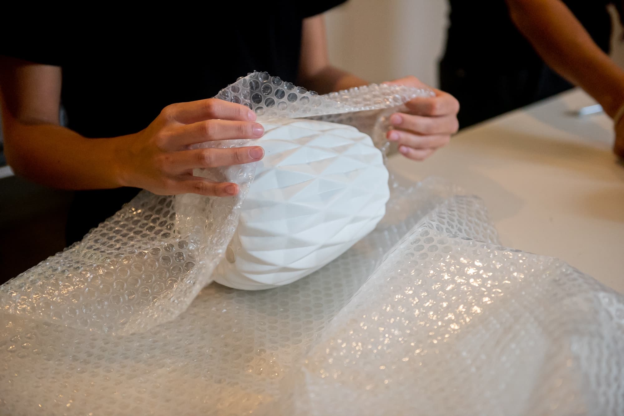 Fragile item being wrapped and packed