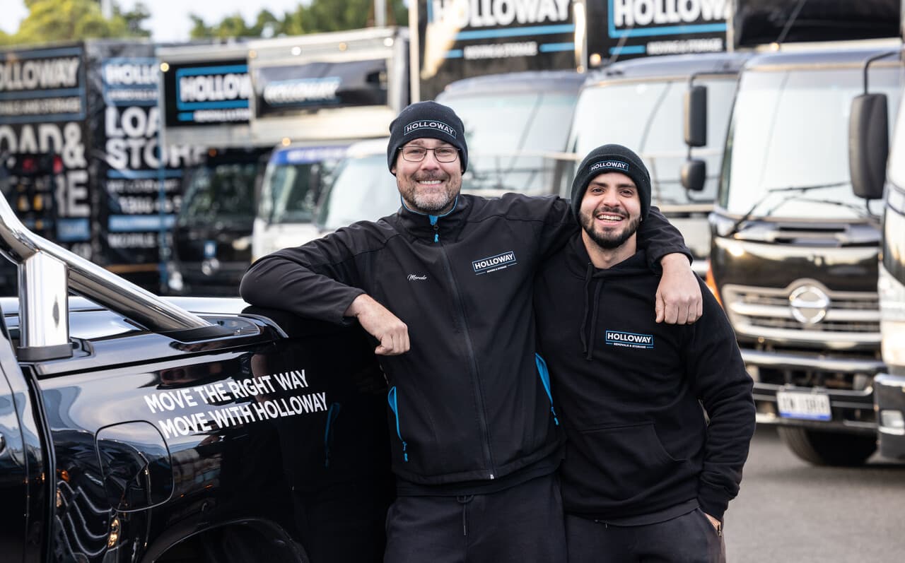 Holloway team posing in front of a truck