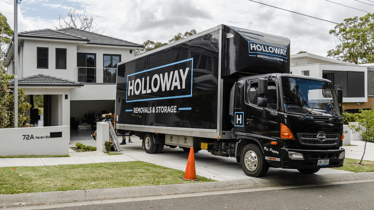 holloway removals truck in front of a house in the middle of a move