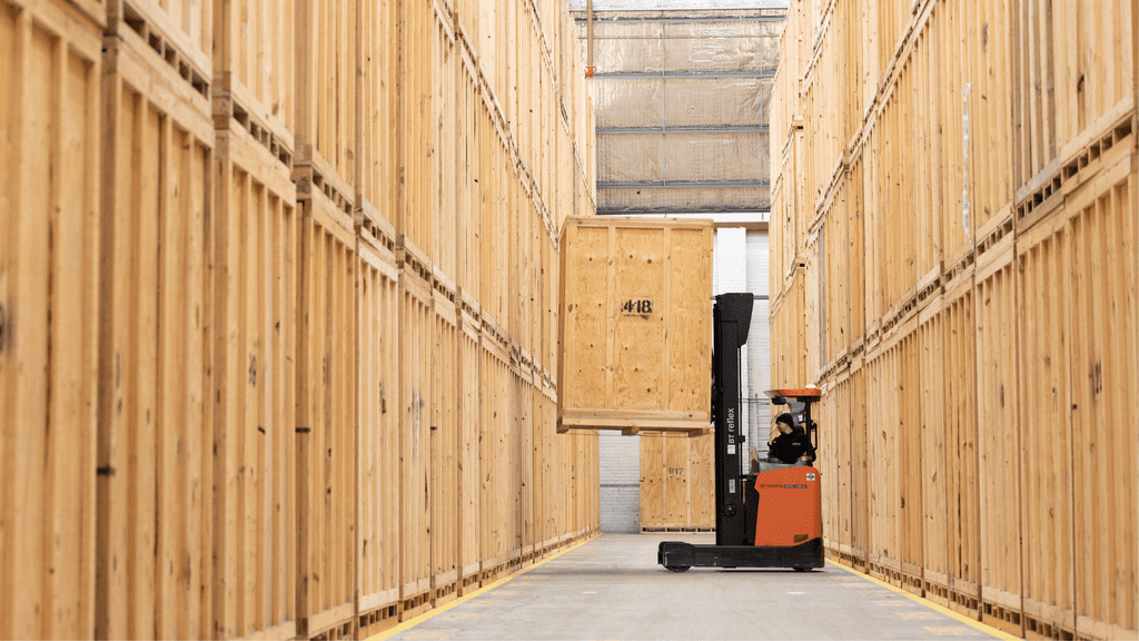 A forklift moving a wooden storage unit in Holloway Removal's Sydney warehouse.