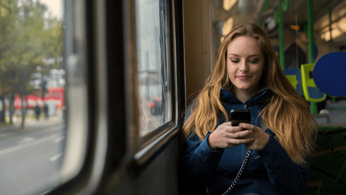 young woman looking at her phone on Melbourne tram
