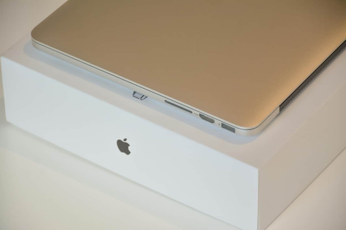 Apple laptop resting on its original white box, to be put inside for safe transport during a move