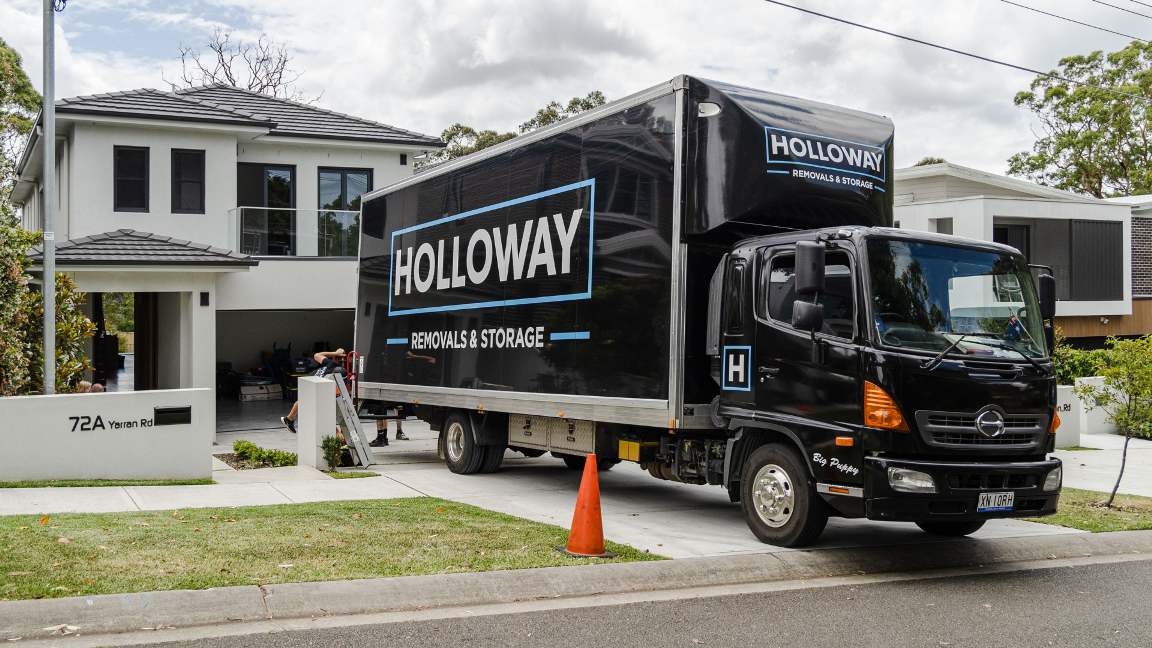 holloway removals truck in front of a house in the middle of a move