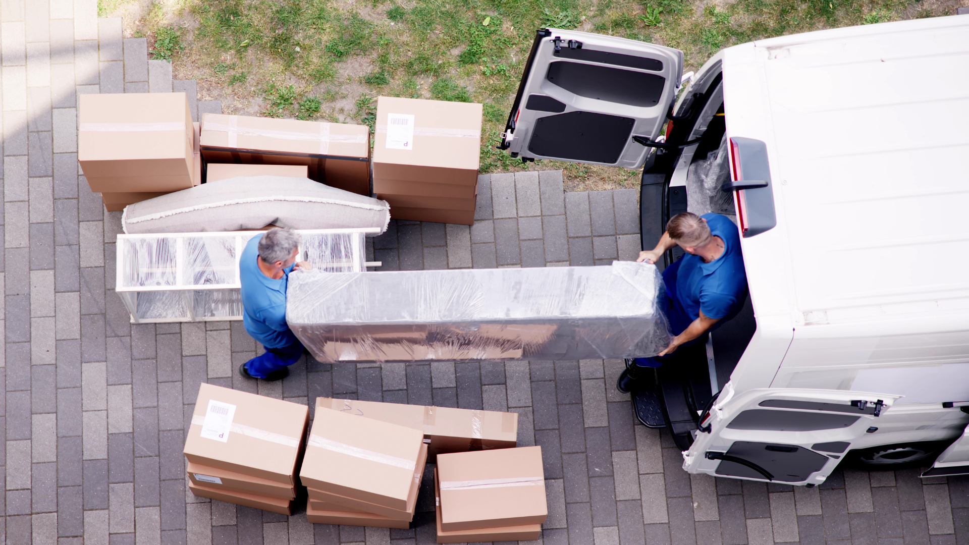 birds eye view of two men moving a mattress into a van representing best moving companies for first home buyers