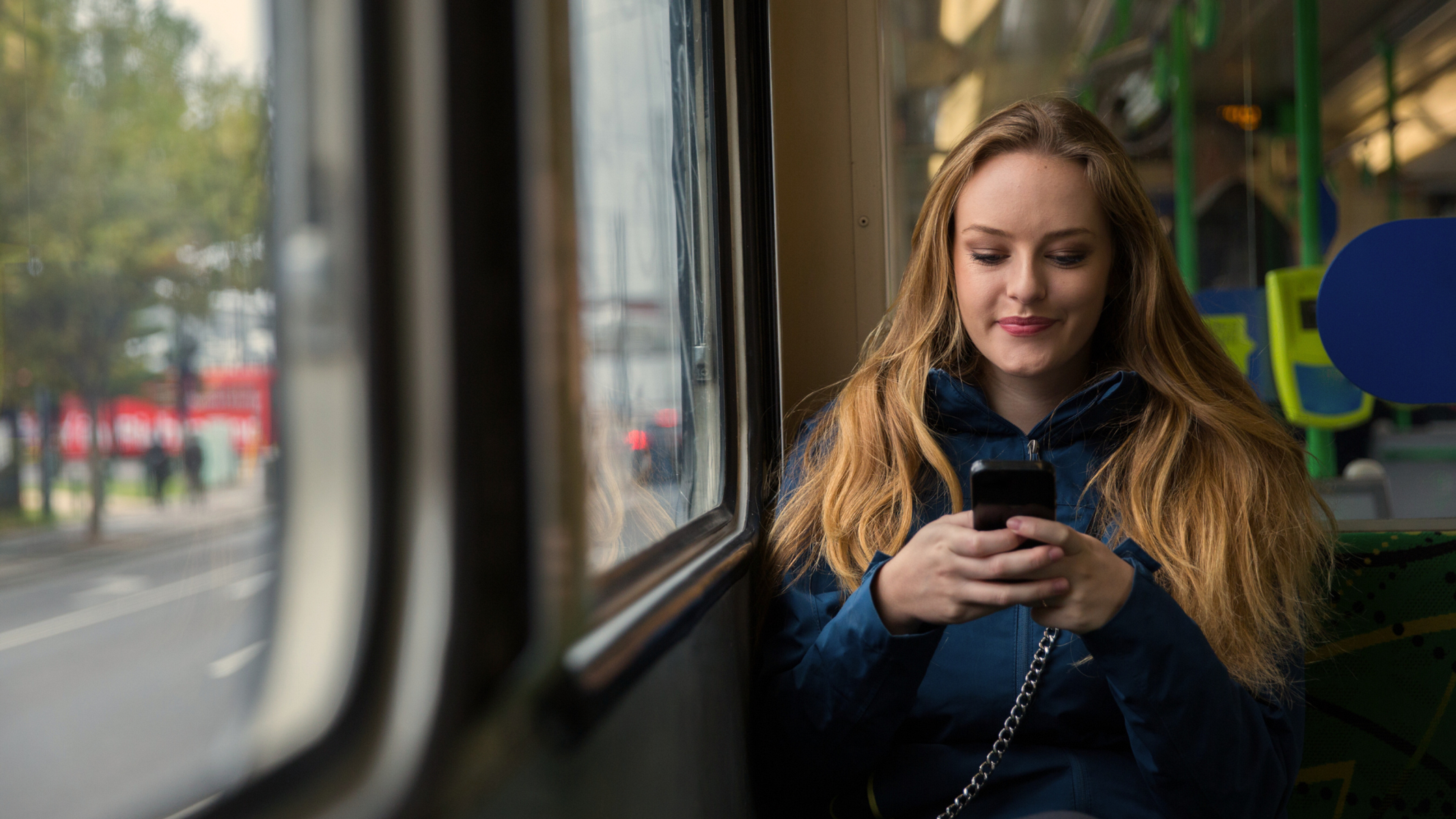 young woman looking at her phone on Melbourne tram